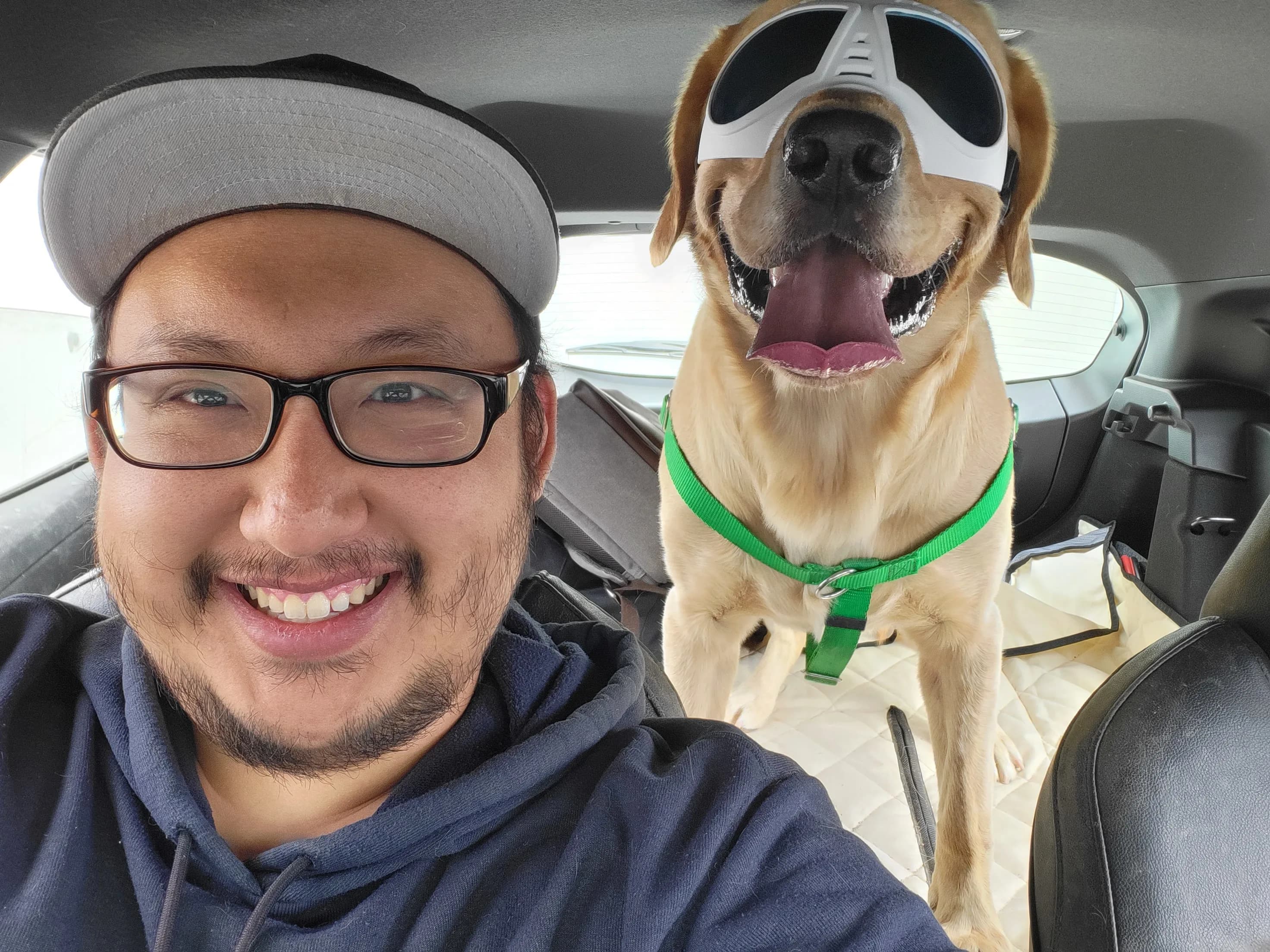 Edward Song smiling in a car beside his Labrador